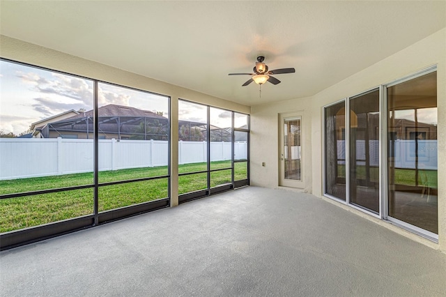 unfurnished sunroom with ceiling fan and a mountain view