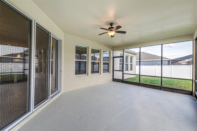 unfurnished sunroom with ceiling fan