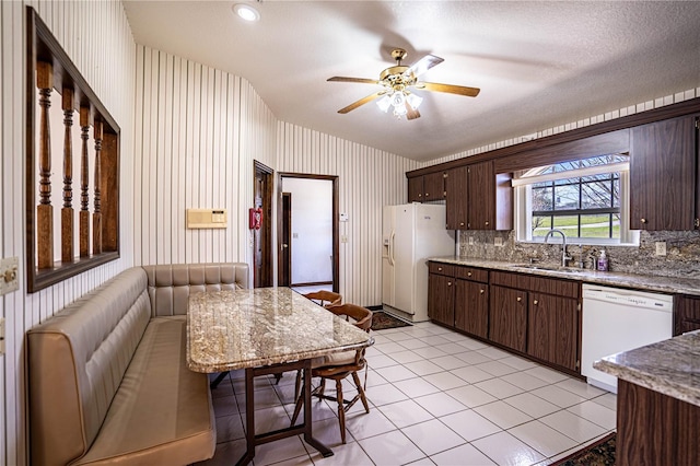 kitchen featuring sink, light tile patterned floors, ceiling fan, dark brown cabinets, and white appliances