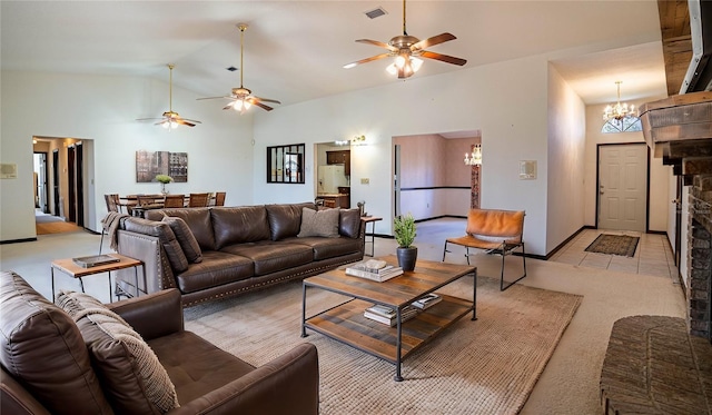 carpeted living room with ceiling fan with notable chandelier and high vaulted ceiling