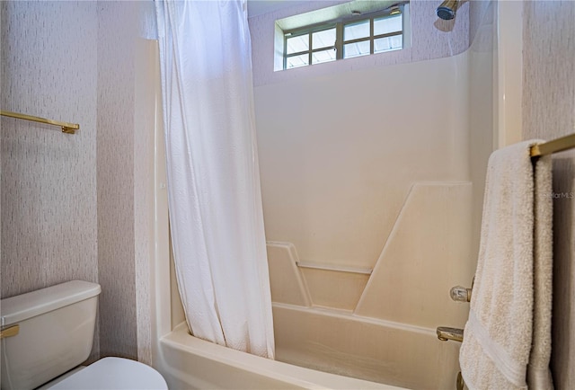 bathroom featuring shower / tub combo with curtain and toilet