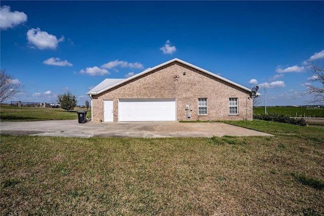 view of side of property featuring a garage and a lawn