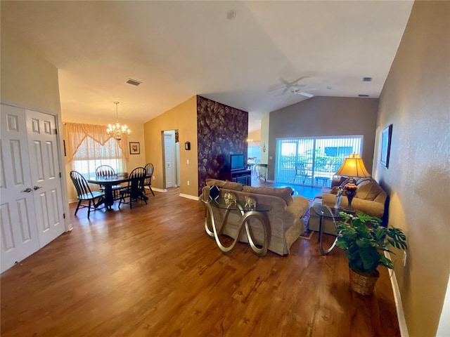 living room with hardwood / wood-style flooring, ceiling fan with notable chandelier, lofted ceiling, and a wealth of natural light