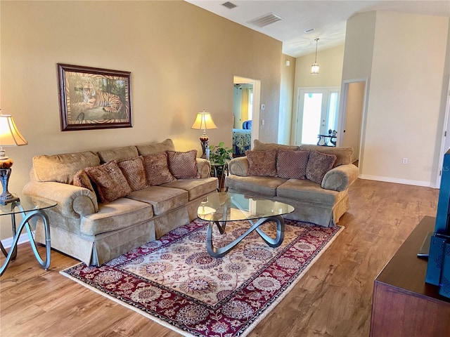 living room with high vaulted ceiling and hardwood / wood-style floors