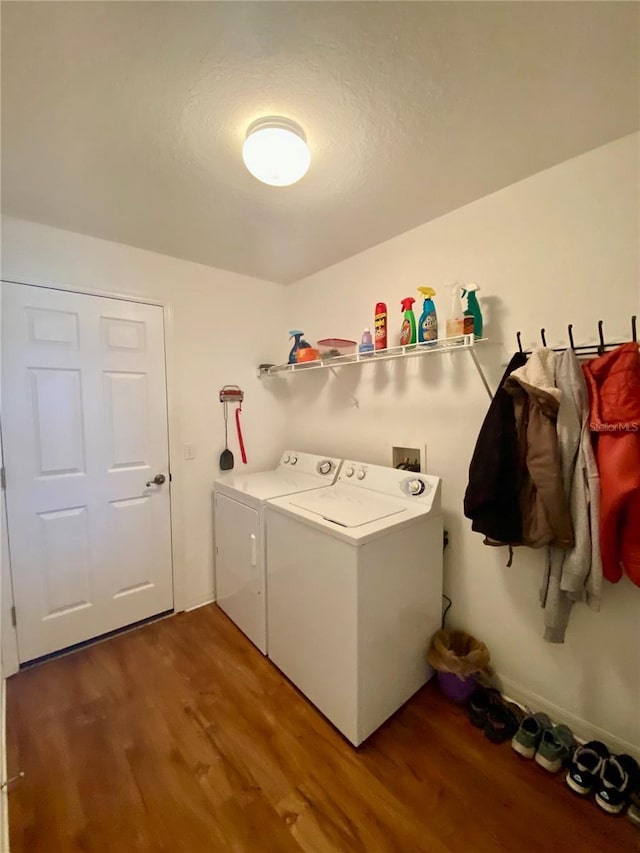 clothes washing area with dark wood-type flooring and washer and clothes dryer