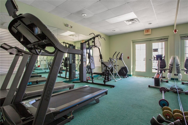 gym featuring a drop ceiling and french doors