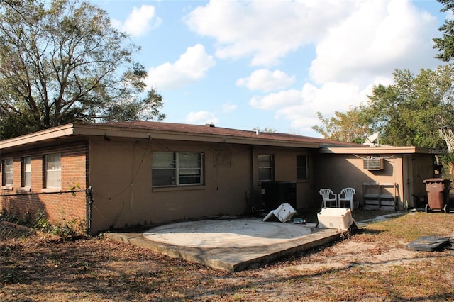 back of property featuring a patio and an AC wall unit