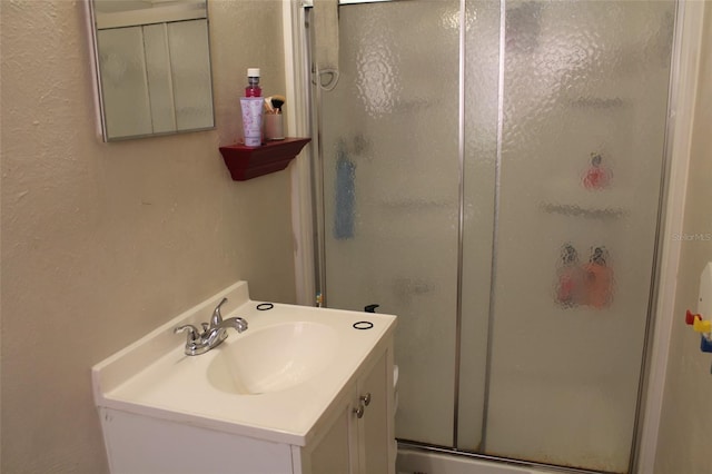 bathroom with vanity and a shower with shower door