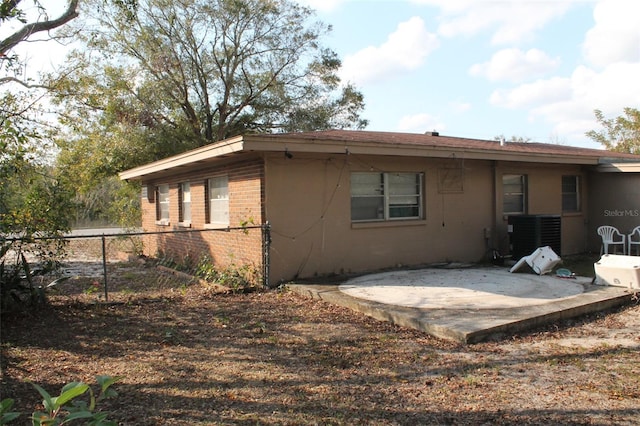 rear view of house featuring cooling unit and a patio