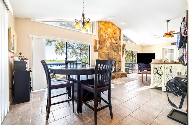 dining space with ceiling fan with notable chandelier and vaulted ceiling