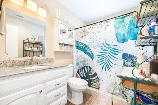 bathroom featuring tile patterned flooring, vanity, a shower with shower curtain, and toilet