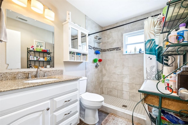 bathroom with vanity, curtained shower, and toilet