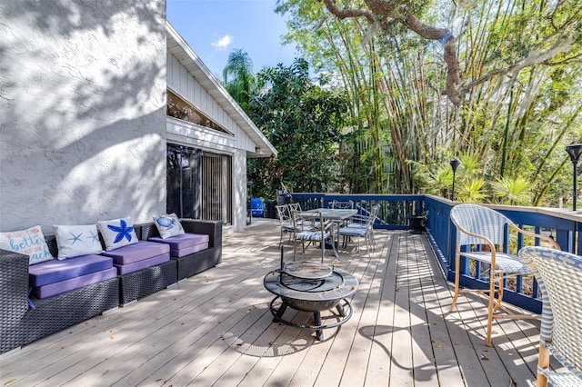 deck with an outdoor living space with a fire pit