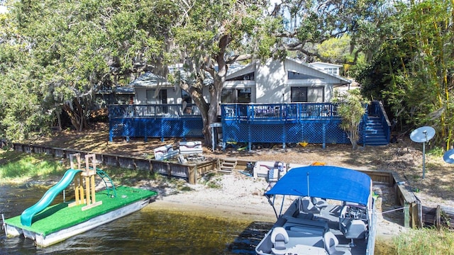 view of dock with a playground and a deck with water view