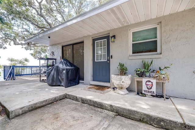 view of exterior entry with a patio area