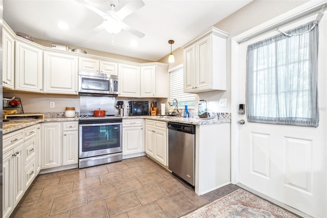 kitchen with white cabinetry, appliances with stainless steel finishes, decorative light fixtures, and light stone countertops