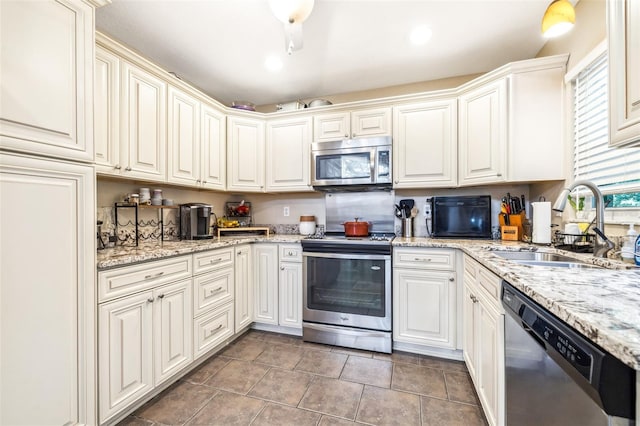 kitchen featuring tile patterned flooring, stainless steel appliances, light stone countertops, and sink