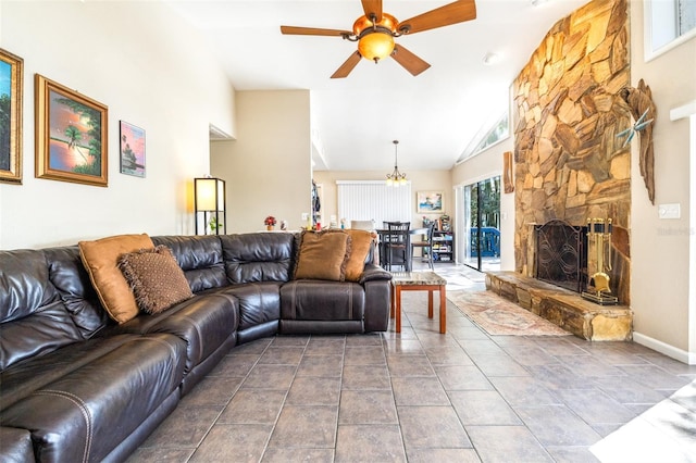 tiled living room featuring ceiling fan, a stone fireplace, and high vaulted ceiling