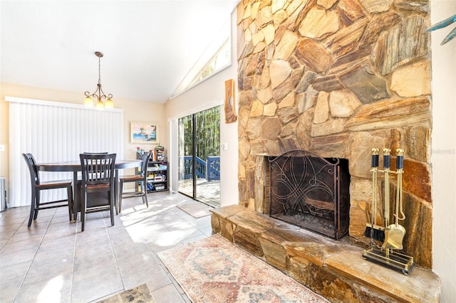 dining room featuring light tile patterned floors, a stone fireplace, a notable chandelier, and high vaulted ceiling