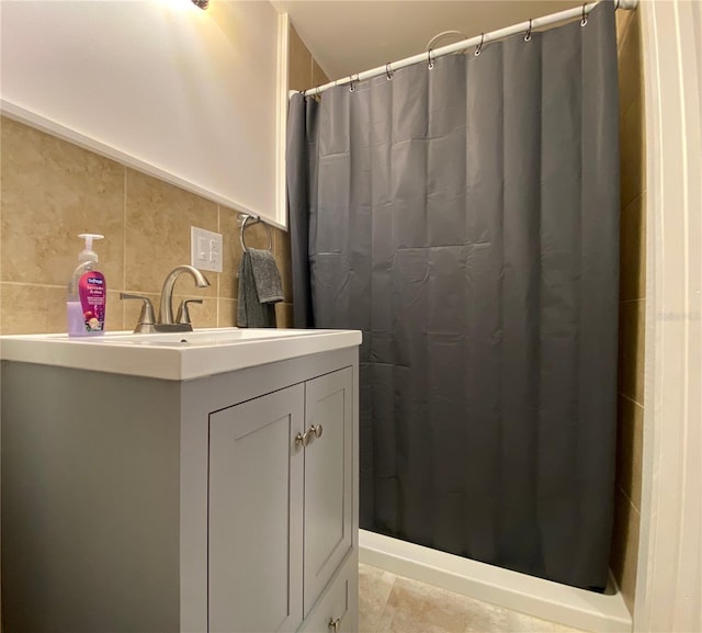 bathroom with tile patterned floors, vanity, curtained shower, and tile walls