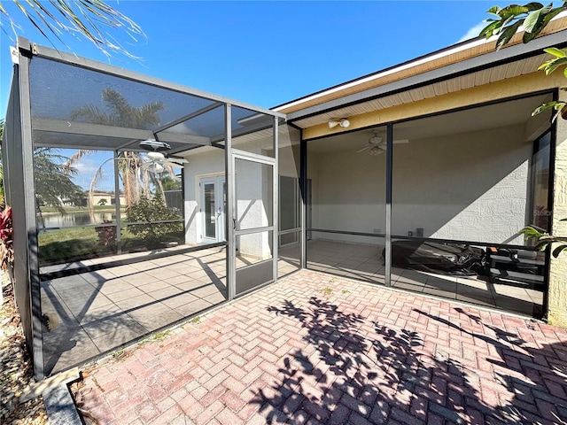 view of patio / terrace featuring ceiling fan and glass enclosure