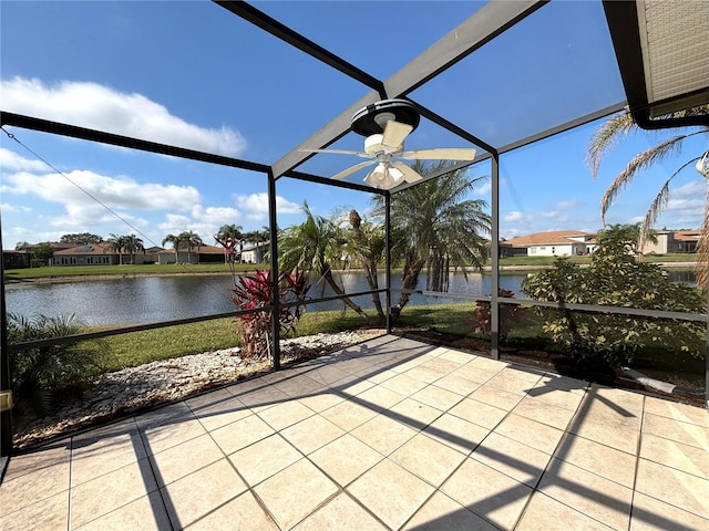 view of patio with ceiling fan, a water view, and glass enclosure