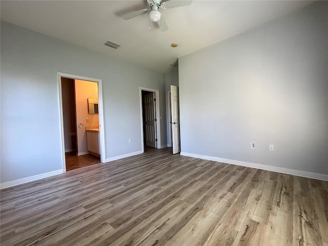 unfurnished bedroom with ceiling fan, light wood-type flooring, and ensuite bath