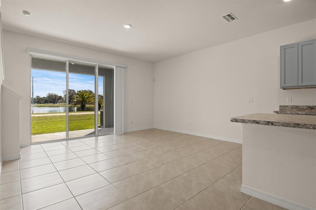 interior space featuring light tile patterned flooring and a water view