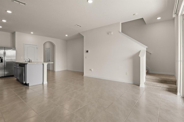 unfurnished living room with sink and light tile patterned floors