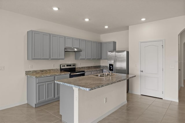 kitchen with appliances with stainless steel finishes, a kitchen island with sink, sink, and gray cabinetry