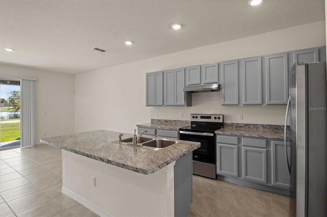 kitchen featuring gray cabinets, light tile patterned flooring, appliances with stainless steel finishes, sink, and a center island with sink