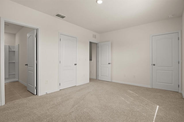 unfurnished bedroom featuring light carpet and connected bathroom