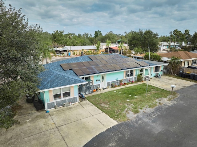 view of front of home with a front yard and solar panels