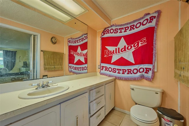 bathroom featuring wooden walls, tile patterned flooring, vanity, toilet, and a textured ceiling