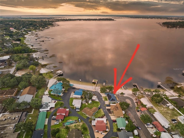 aerial view at dusk featuring a water view