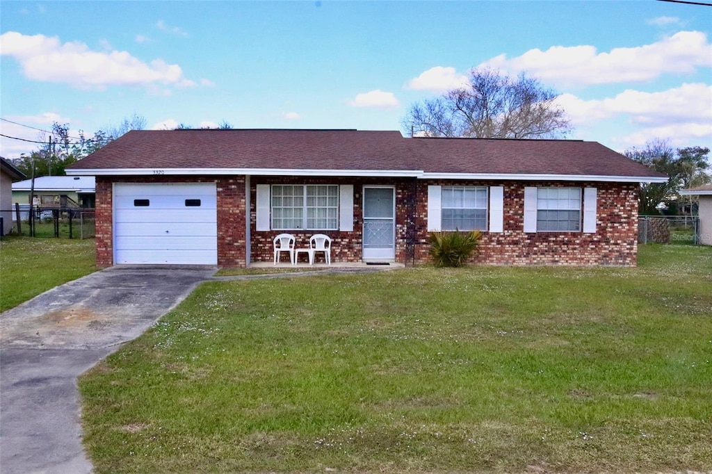 single story home featuring a garage and a front lawn