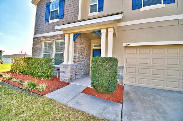 view of exterior entry featuring a garage and a porch