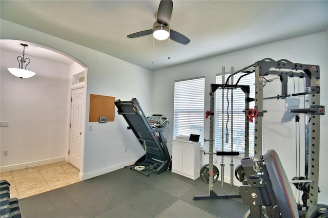 exercise area with ceiling fan and a textured ceiling