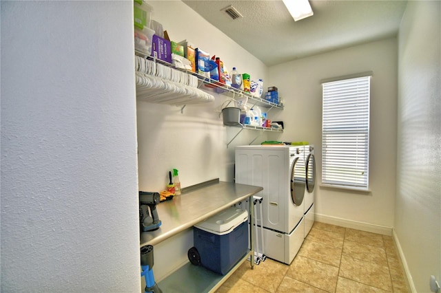 washroom featuring light tile patterned floors and washing machine and clothes dryer