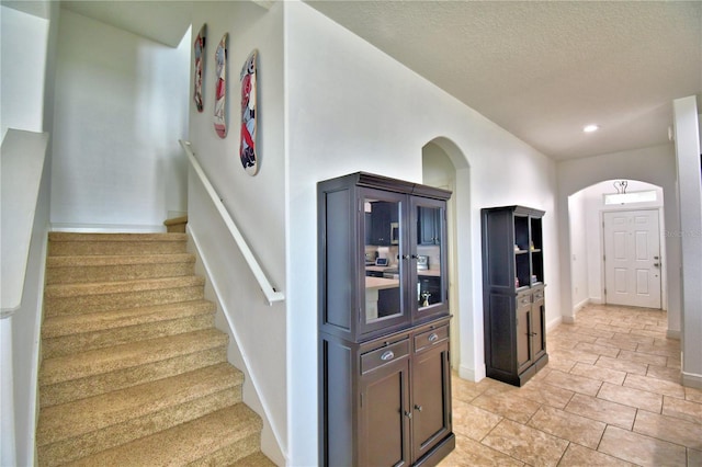 stairs featuring a textured ceiling