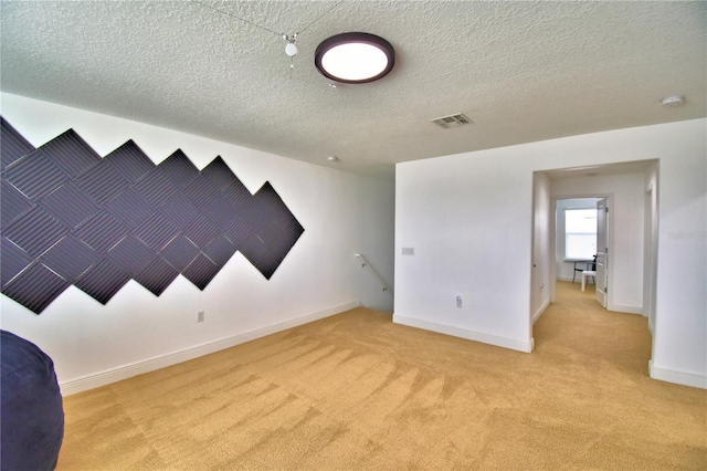 carpeted spare room with a textured ceiling