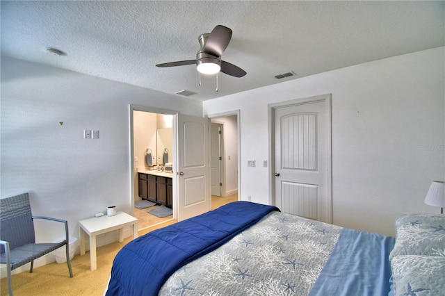 bedroom with ensuite bathroom, light colored carpet, ceiling fan, a textured ceiling, and a closet