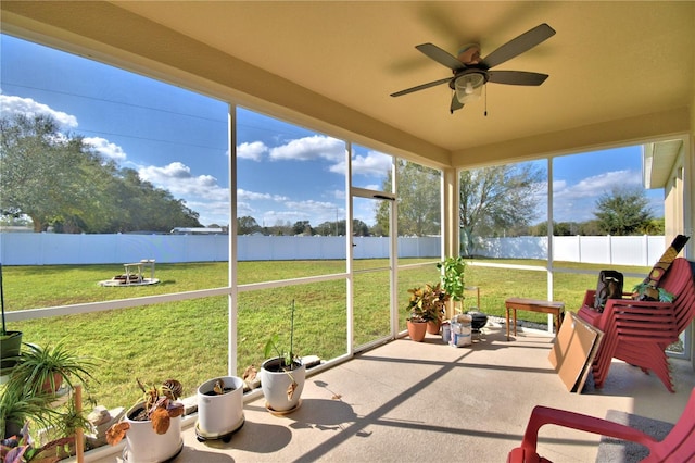 unfurnished sunroom with ceiling fan