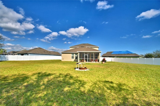 rear view of property with a sunroom and a lawn