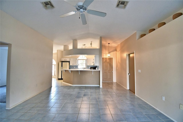 unfurnished living room with lofted ceiling, tile patterned floors, and ceiling fan