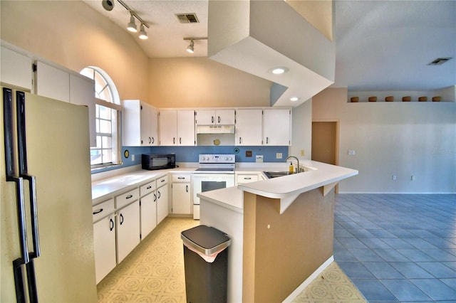 kitchen featuring sink, white appliances, a breakfast bar area, white cabinetry, and light tile patterned flooring