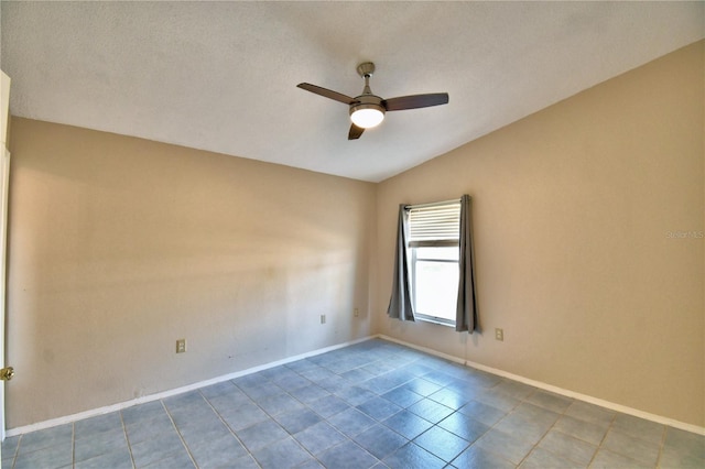 spare room with light tile patterned floors, vaulted ceiling, and ceiling fan