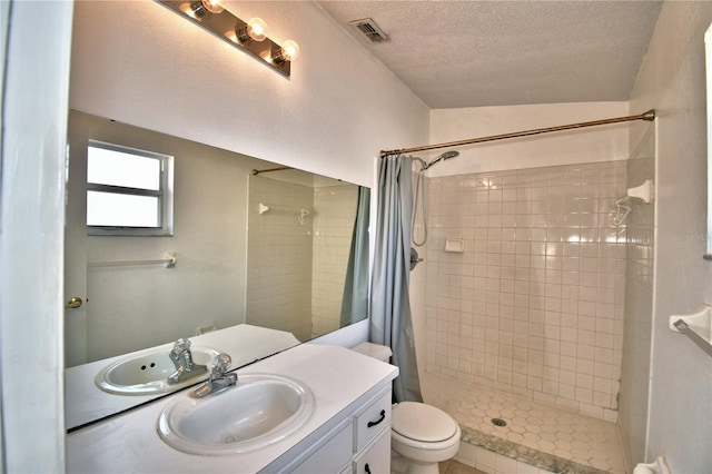 bathroom with vanity, toilet, a textured ceiling, and a shower with shower curtain