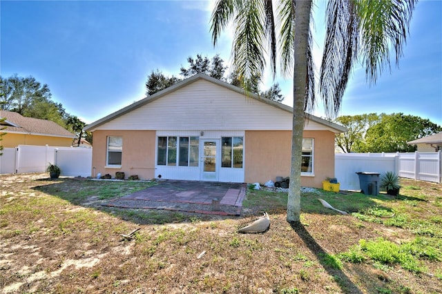 rear view of property with a yard and a patio area