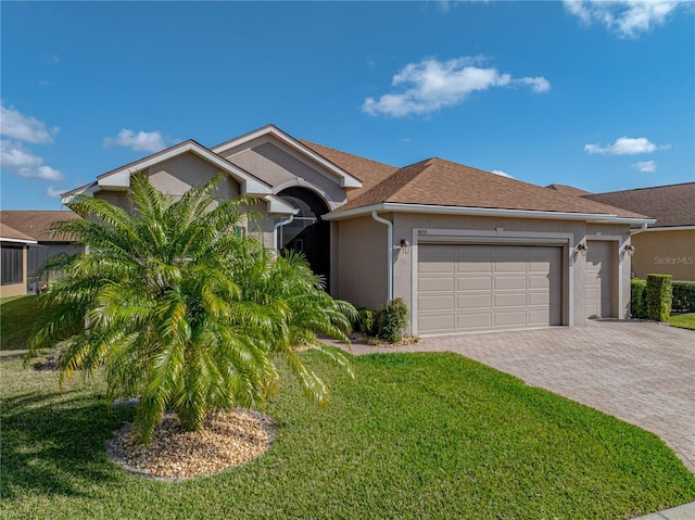 single story home featuring a garage and a front lawn